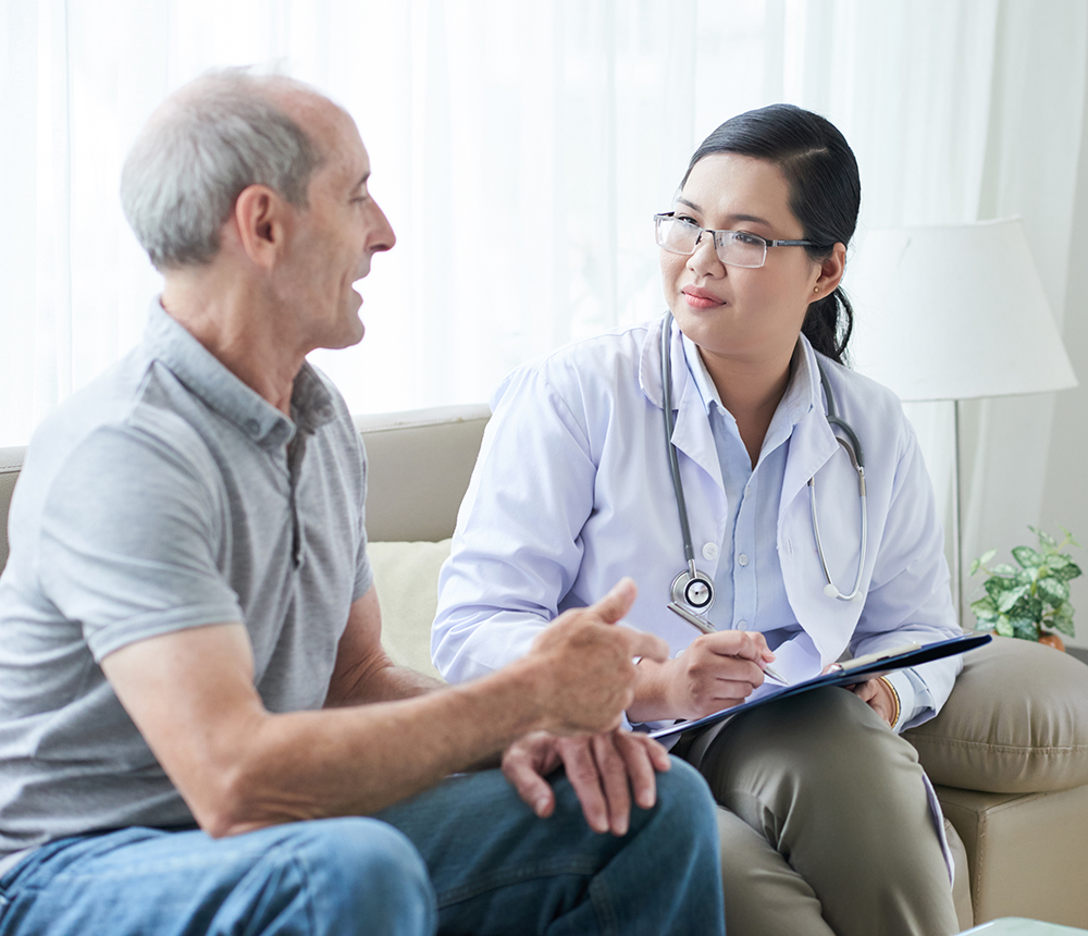 Doctor talking to senior client at home