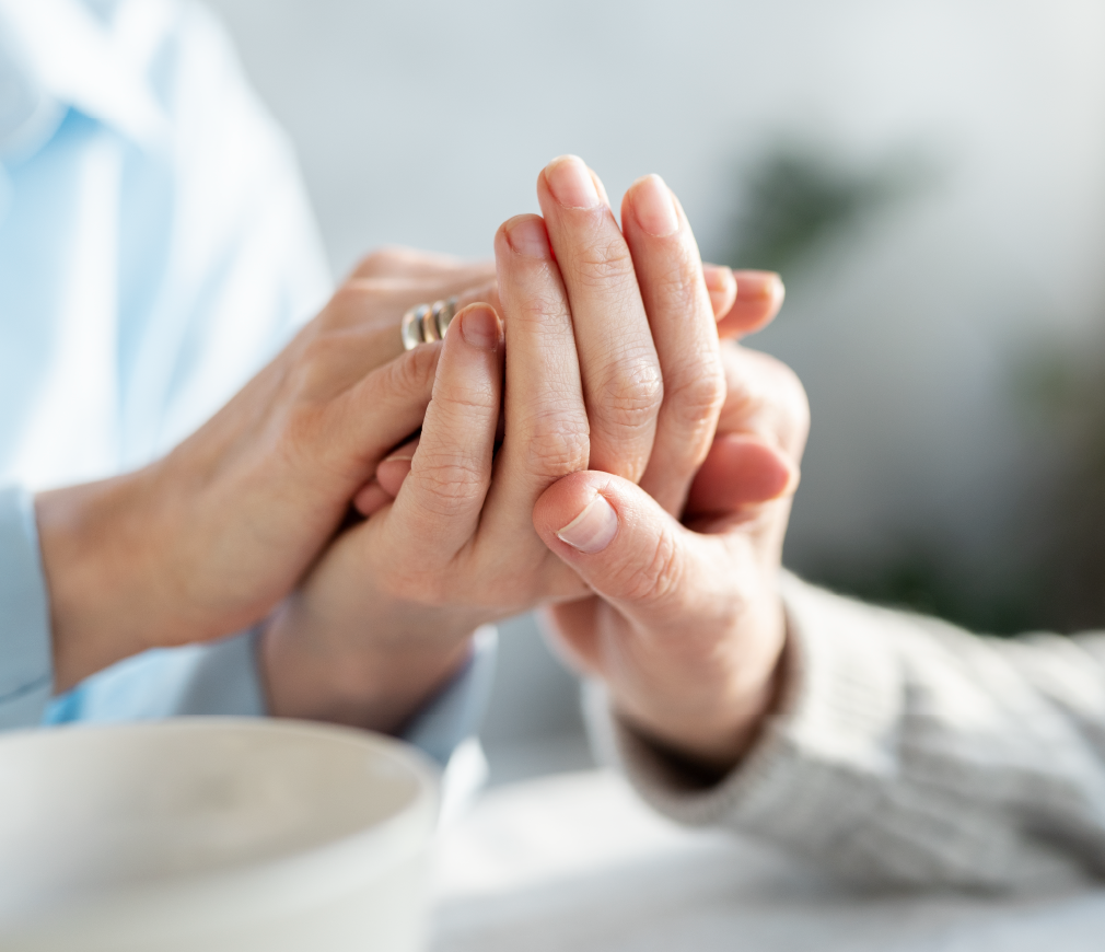 Patient and caregiver holding hands