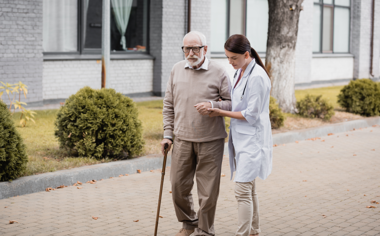 Man with ALS being helped by a caregiver