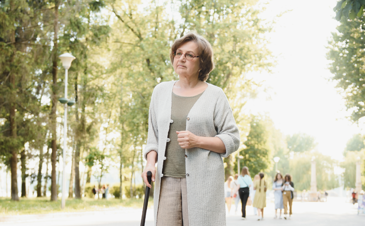 Woman with Multiple System Atrophy using a cane to walk