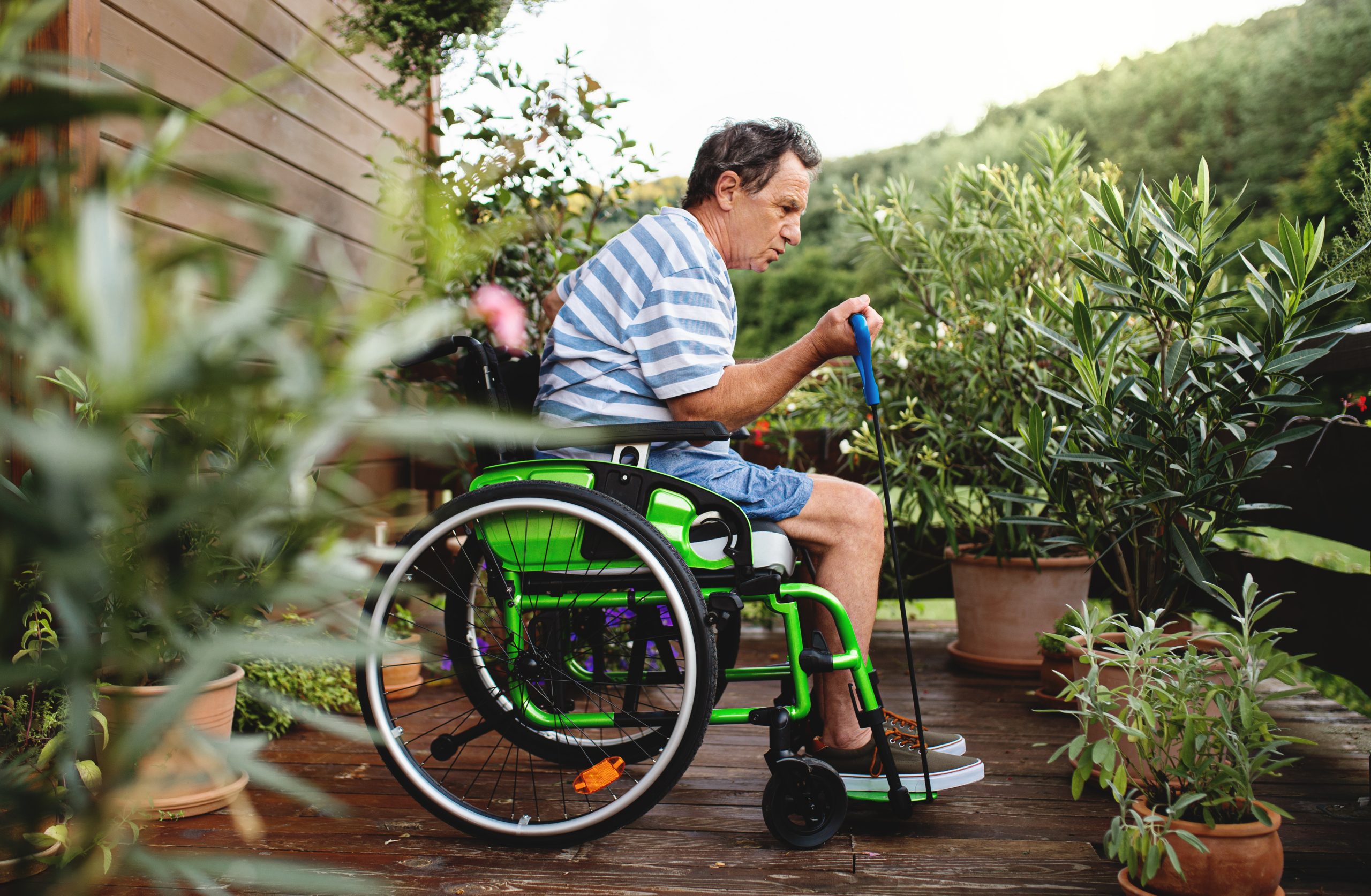 white man in wheelchair doing exercise in garden
