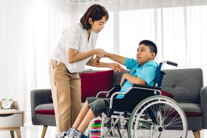 Boy with Duchenne in a wheelchair. Signs of loss of arm strength