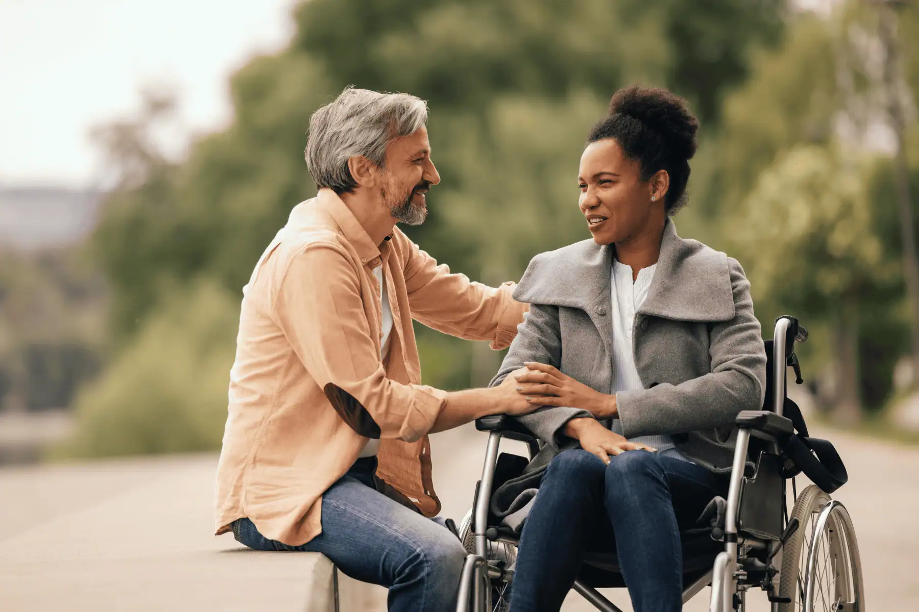 Two people sitting outside having a discussion, one in a wheelchair