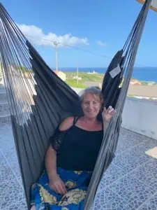 A lady sitting in a hammock swing smiling