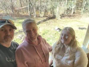 Family photo of a couple and their daughter outside in a park